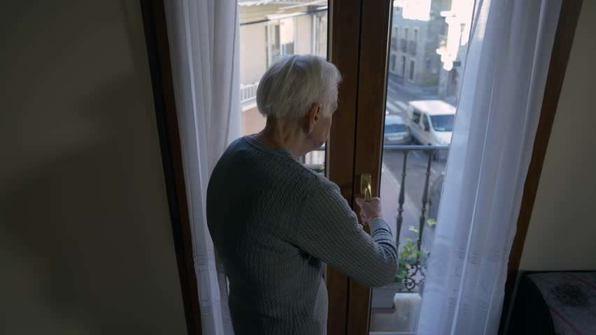 Tracking shot of senior grey-haired female retiree opening balcony door walking out. Live camera follows old Caucasian woman resting at home on summer day. Aging and lifestyle concept | Shutterstock HD Video #1099123271