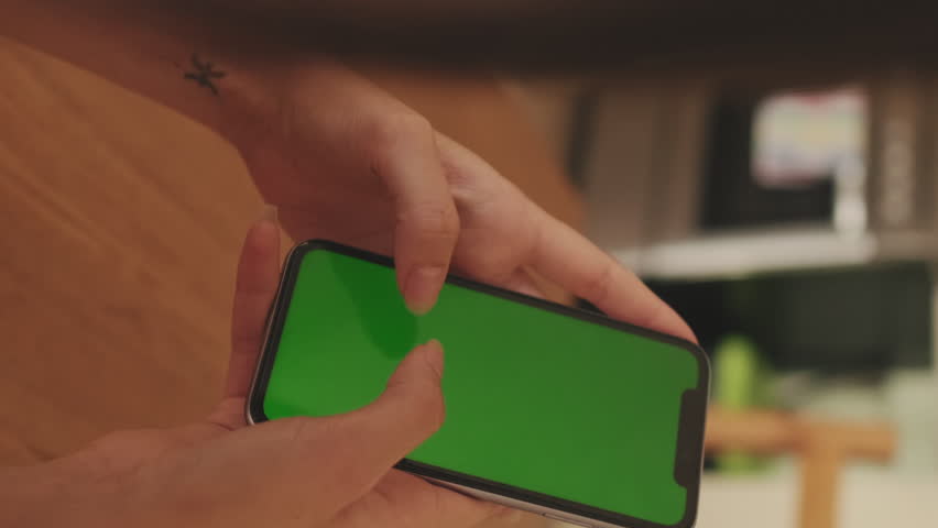 VERTICAL VIDEO, Close-up of young woman's hands using mobile phone green screen chroma key at home | Shutterstock HD Video #1099123535