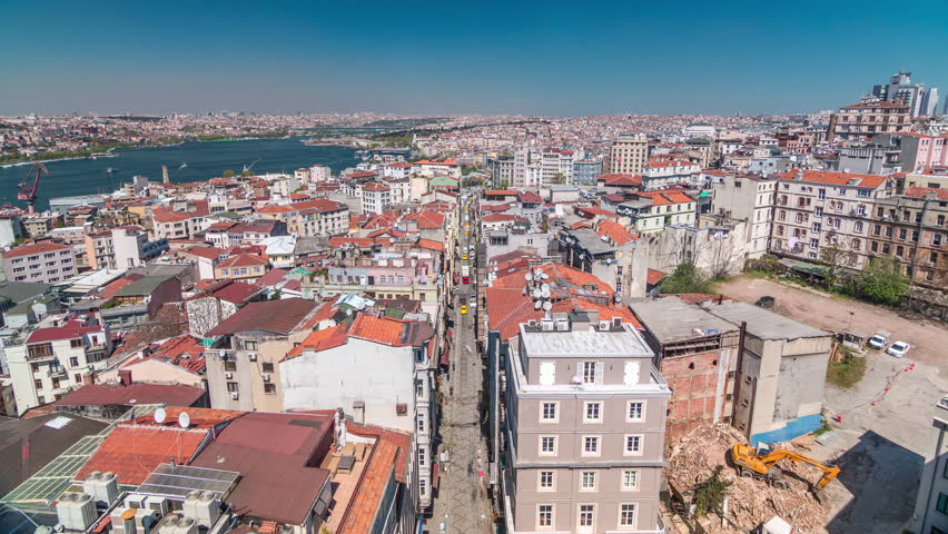 The view from Galata Tower to Golden Horn and city skyline with red roofs timelapse. Beyoglu region and Sultanahmet on the opposite shores of Golden Horn, Istanbul, Turkey. Ferries traffic at sunny