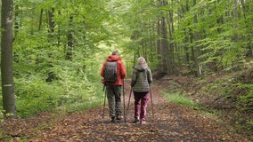 Rear view of senior couple hiking in autumn forest. - Powered by Shutterstock - Get 15% off with code: PIKWIZARD15