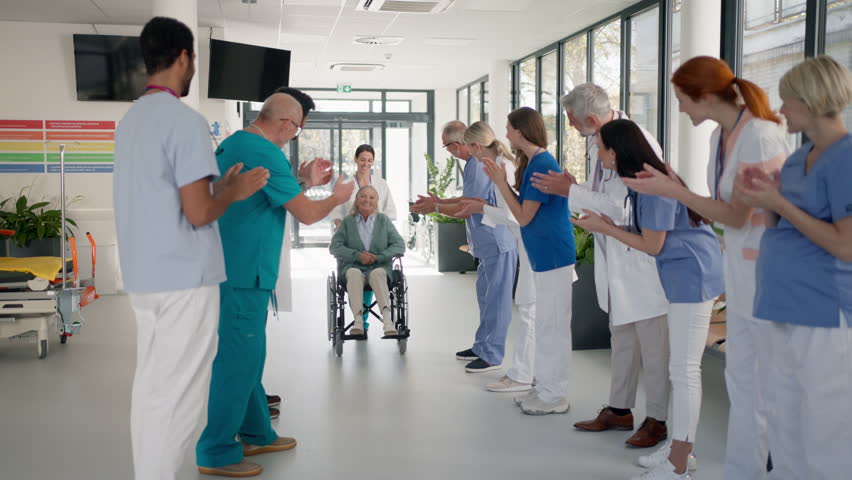 Medical staff clapping to senior patient who recovered from serious illness. Royalty-Free Stock Footage #1099126705