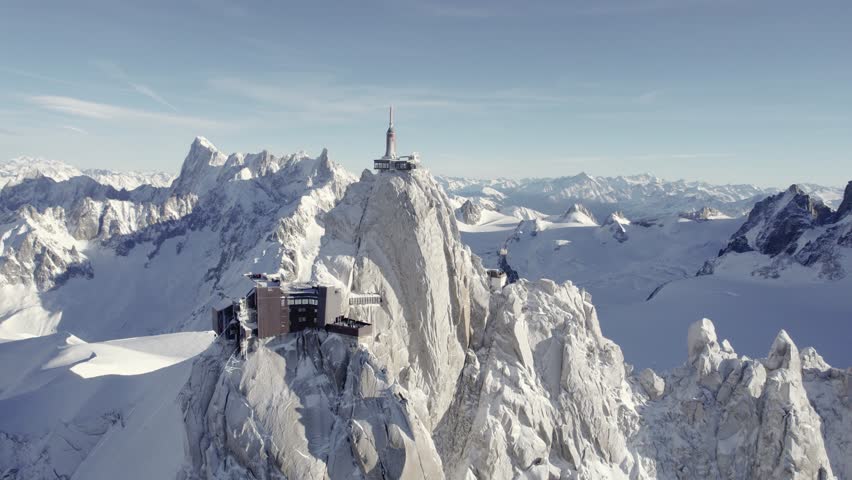 Aiguille du Midi observatory at the Mont Blanc Mountain peak summit including visitor center and weather station, Aerial dolly out shot