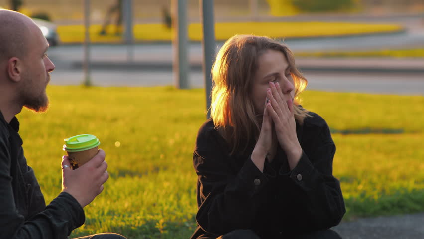 Date. Young man and woman in city park, parking lot, lawn, grass. They eat pizza. Fooling around, having fun, smiling. Drink coffee. | Shutterstock HD Video #1099135805