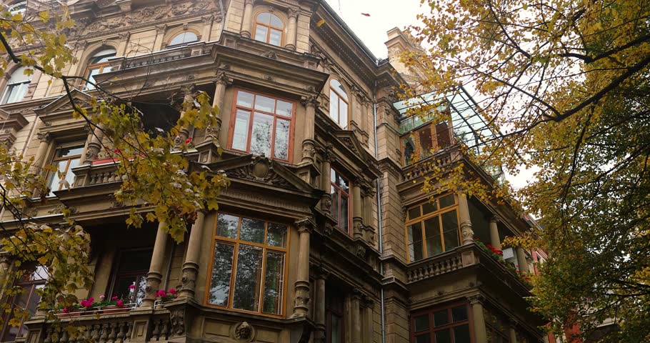 Leaving old city mansion after rainy october day surrounded autumn trees. High quality 4k footage