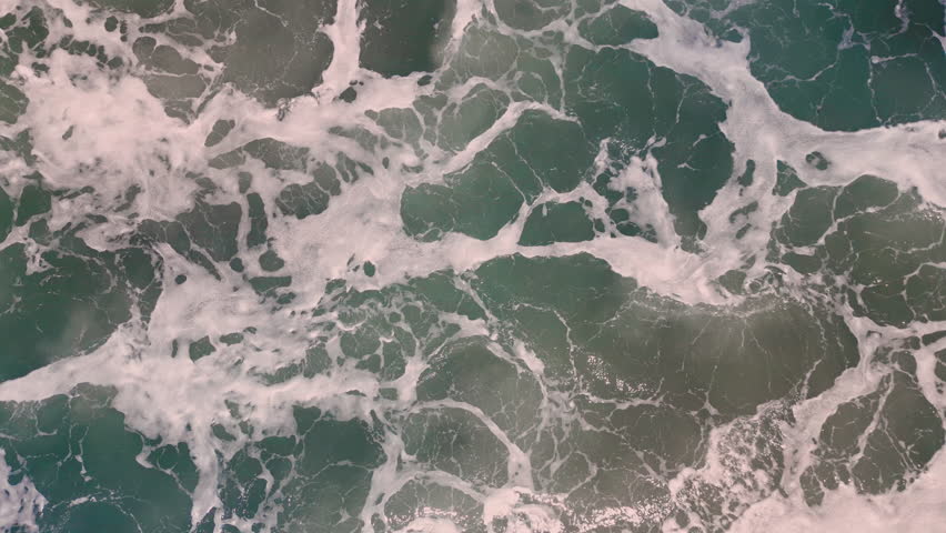 Aerial top view footage of fabulous sea tide on a stormy day. Drone filming breaking surf with foam in Vietnam ocean. Big swell in Asia. Beautiful texture of big power dark ocean waves with white wash | Shutterstock HD Video #1099141569