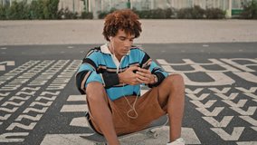 Smiling zoomer shooting smartphone at street closeup. Earphones guy listening music at mobile outdoors zoom on. Millennial hipster gesturing cool at city. Positive teen creating social media content - Powered by Shutterstock - Get 15% off with code: PIKWIZARD15