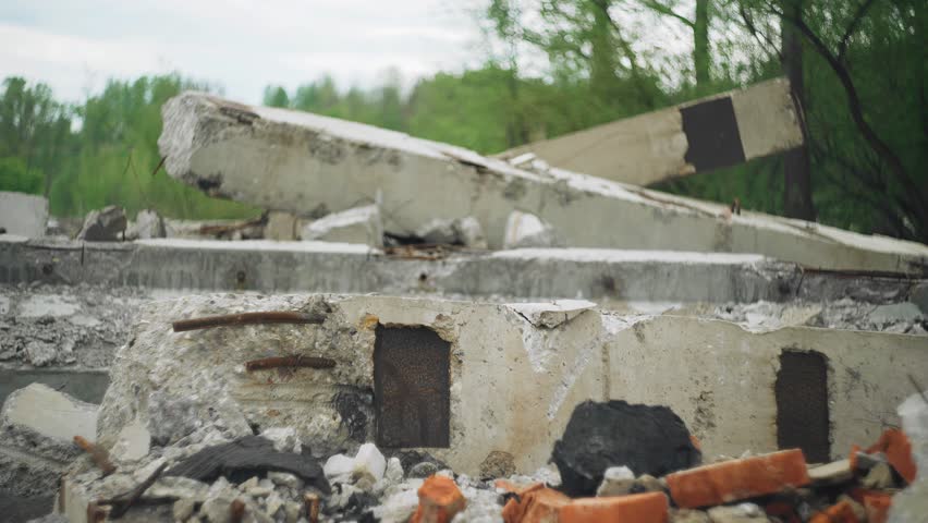 A tired man walks along the concrete rubble walking among this devastation