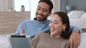 Asian couple streaming movies on tablet, watch funny video on subscription service online and talking about social media notification on sofa in home. Happy, comic and smile man and woman on tech - Powered by Shutterstock - Get 15% off with code: PIKWIZARD15