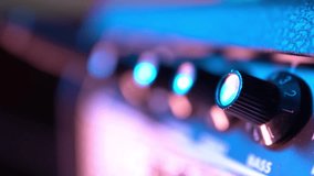 Adjusting tone knobs on a guitar amplifier - Powered by Shutterstock - Get 15% off with code: PIKWIZARD15