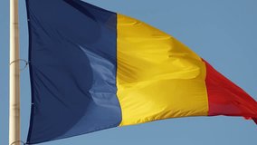 Close up view of the national flag of Romania waving against blue sky background. 4k video in Bucharest.