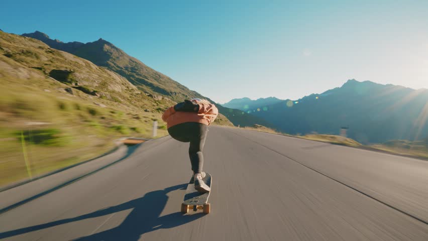 Cinematic downhill longboard session. Young woman skateboarding and making tricks between the curves on a mountain pass. Concept about extreme sports and people	 Royalty-Free Stock Footage #1099160553