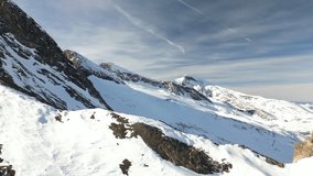 High quality footage of snow covered mountains in Europe on a sunny day. Drone video of ski resort. Cinematic clip for hiking and mountaineering.