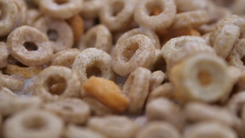 Milk being poured over cereal cheerios close up