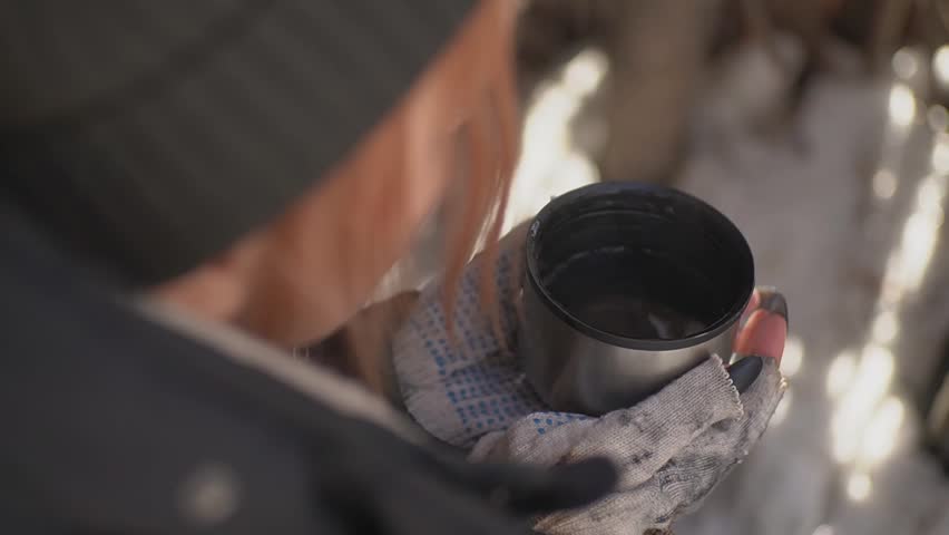homeless girl holding a hot drink in her hands. High quality Full HD video recording