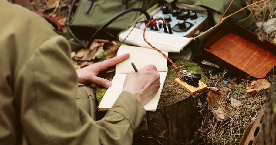Russian Soviet Infantry Red Army Soldier In World War II using Russian Soviet Portable Radio Transceiver In Trench Entrenchment In Spring Autumn Forest. 4K. Headphones And Telegraph Key. Close Up