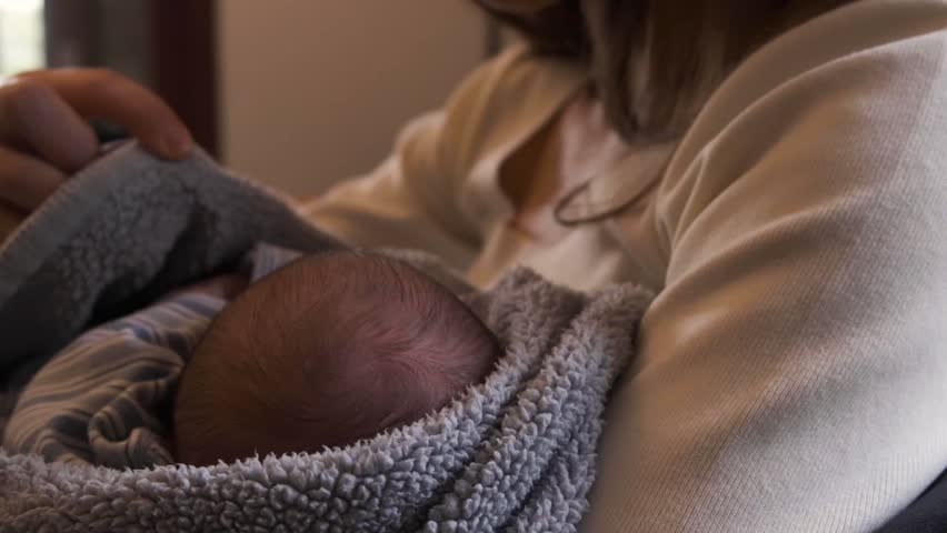 mom and baby. Mother holding a baby. covering the baby with a blanket to keep him warm. Mom taking care of a newborn infant. family concept love of a newborn. Parenthood. infants head in a blanket Royalty-Free Stock Footage #1099168723