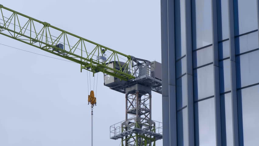Construction site, where a modern beautiful multi-storey building is being erected by casting a monolith into a formwork reinforced with metal reinforcement. The crane carries the necessary loads | Shutterstock HD Video #1099169093