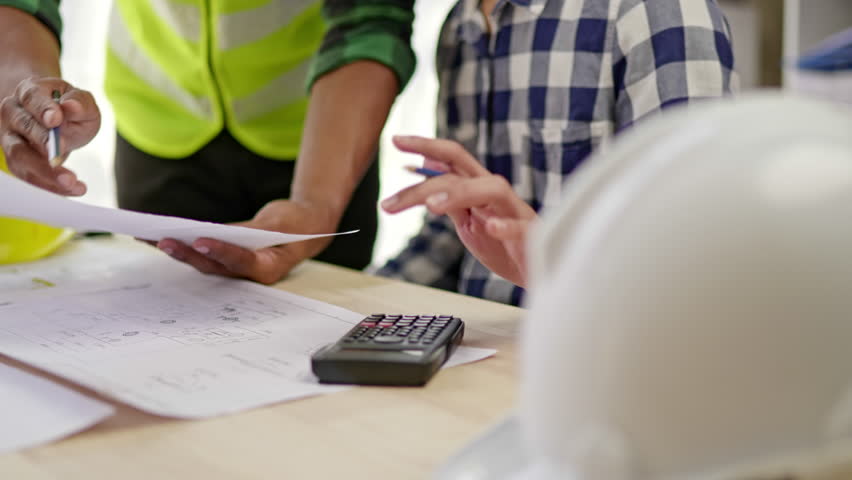 Close up of hands working brainstorming and measuring for cost estimating on paperworks and floor plan drawings about design architectural and engineering for houses and buildings. Royalty-Free Stock Footage #1099169785