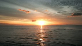 Sea scenery. Cinematic drone aerial view beautiful evening sunset in sky over sea. Sun path is reflected in sea surface. Sunrise in morning aerial shot.