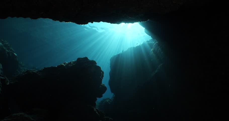sun rays sun beams and sun shine underwater in cave beautiful light scenery in ocean scuba divers to see in cave backgrounds Royalty-Free Stock Footage #1099174861