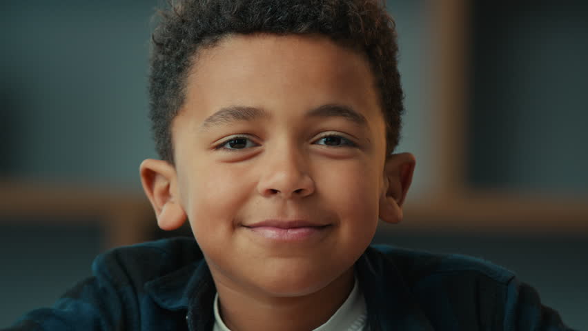 Close up portrait at home indoors little African American school boy ethnic son pupil schoolboy child kid male baby schoolkid orphan smiling looking at camera friendly face adoption custody children | Shutterstock HD Video #1099176297