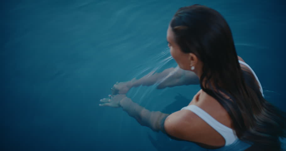 Beautiful young woman swimming underwater in luxury pool on vacation at tropical resort spa | Shutterstock HD Video #1099180727