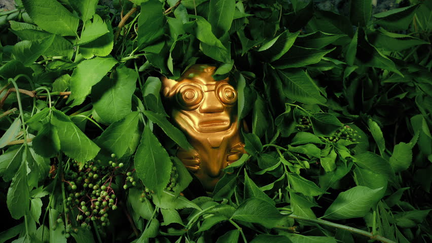 Golden Idol In The Jungle With Plants Moving In Breeze