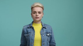 Close-up view of a girl with blonde, short hair looking cheerfully. Young woman holding white paper and inspiring to move. High quality 4k footage