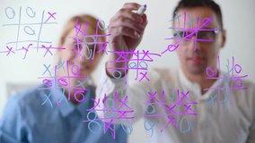 Man and woman playing game on a glass board with colorful markers. Two players take turns putting Os or Xs in a pattern of nine squares. High quality 4k footage