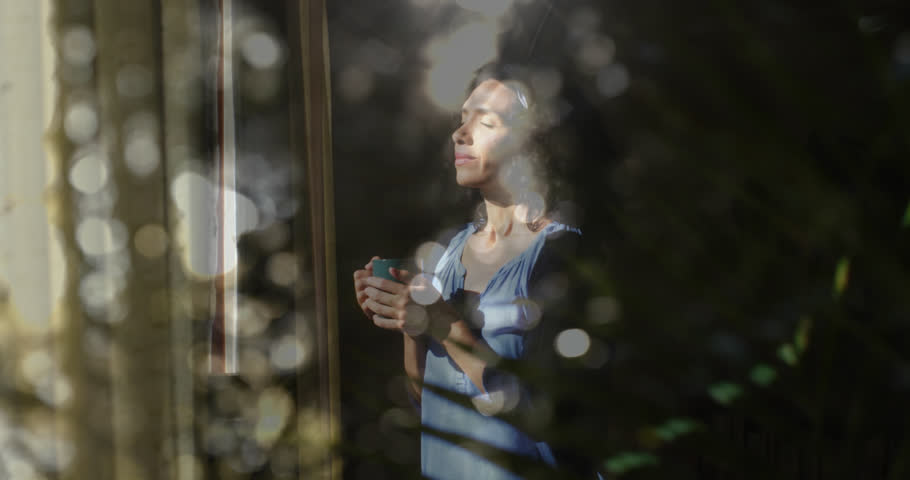 Animation of white spots of light over biracial woman drinking tea. Lifestyle, wellbeing and leisure time concept digitally generated video. | Shutterstock HD Video #1099189607