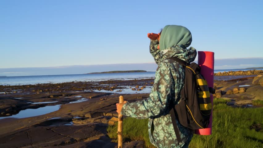Woman with backpack and stick watching to horizon. 4k footage UHD 3840x2160 