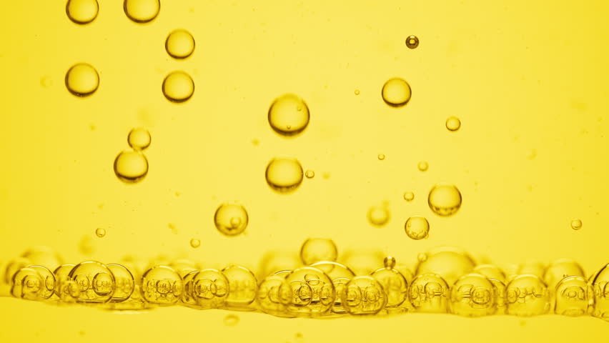 Shot of a lot of different sized yellow transparent bubbles of chamomile oil go down to another ones on yellow background | Background shot for skin care products with chamomile oil commercial | Shutterstock HD Video #1099197369