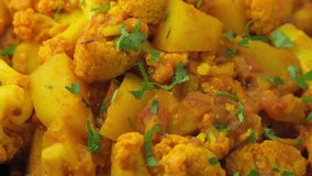 Aloo Gobi traditional Indian dish with cauliflower and potato. Rotating video.