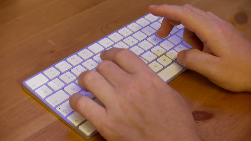 Fingers typing on computer keyboard on wooden desk | Shutterstock HD Video #1099201155
