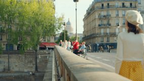 Attractive girl walking on the embankment bridge in Paris