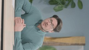 Vertical Video of Pensive Mature Adult Businessman Thinking while Sitting in Office