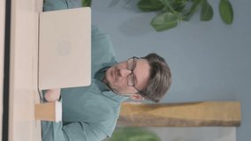 Vertical Video of Mature Adult Man Reacting to Loss While Working in Office