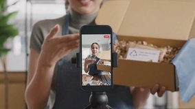 SME owner go green net zero retail store live stream talk on phone showing eco care plastic free packaging box Asia people young woman record video on   reel  shop happy side hustle - Powered by Shutterstock - Get 15% off with code: PIKWIZARD15