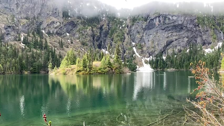 Tranquil, turquoise Lake Angeles surrounded by steep cliffs of rock and evergreen trees in the mountains of the Olympic National Park - Nr Port Angeles, Washington, USA