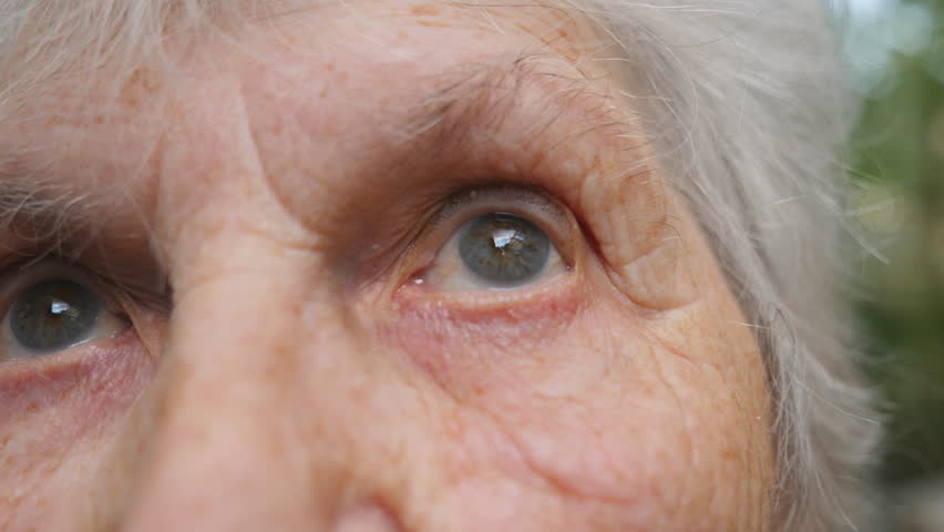 Close up portrait of old woman looking up. Eyes of an elderly lady with wrinkles around them. Slow motion | Shutterstock HD Video #1099215923