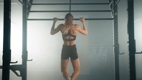 Back view of caucasian fitness girl during her morning workout session at the gym. Young, healthy woman using the pull up bar to train all muscle groups. High quality 4k footage - Powered by Shutterstock - Get 15% off with code: PIKWIZARD15