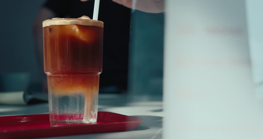 Preparation process of refreshing espresso tonic being made by professional barista. New style coffee drinks in specialty coffee place.