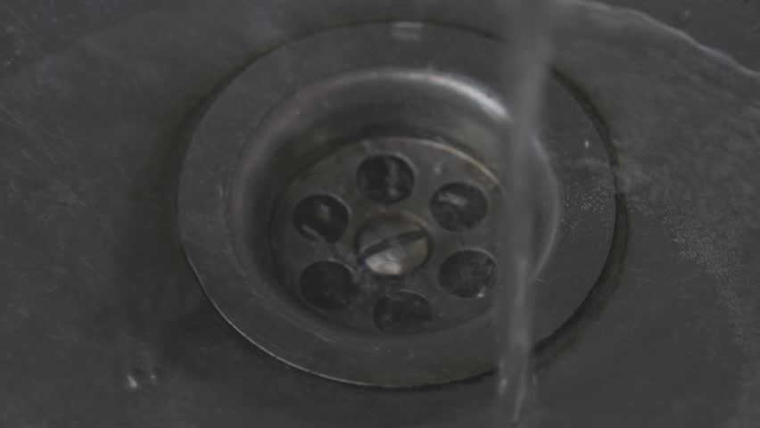 Tap water flows into a tin sink. smooth zoom | Shutterstock HD Video #1099221225