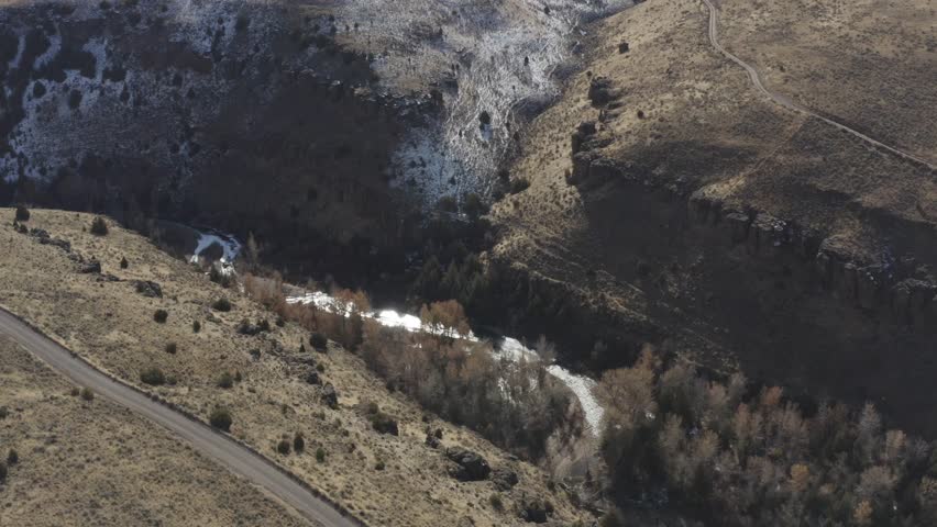A drone lowers over a canyon in Rural Idaho with melting snow.