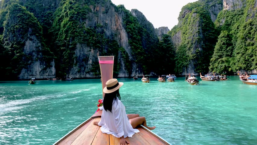 Asian Thai women in front of a longtail boat at Koh Phi Phi Island Thailand, Pileh Lagoon. | Shutterstock HD Video #1099230511