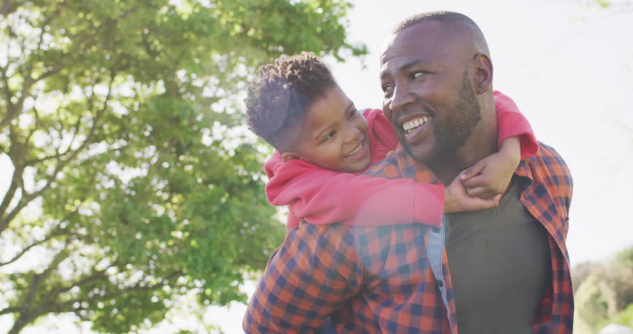 Happy african american father and his son embracing in garden. Spending quality time at home. | Shutterstock HD Video #1099231059
