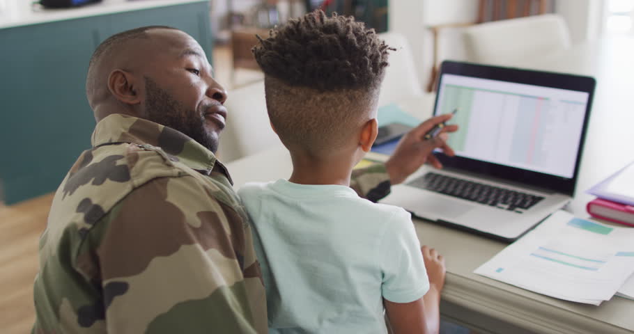African american father with son learning together with laptop. Spending quality time together, army and patriotism concept. Royalty-Free Stock Footage #1099231607