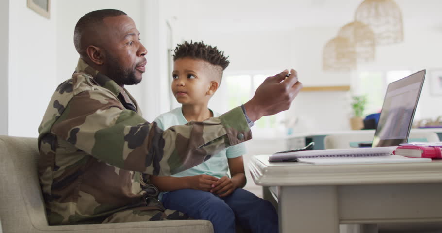 African american father with son learning together with laptop. Spending quality time together, army and patriotism concept. Royalty-Free Stock Footage #1099231609