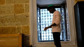 African black young man goes to prostrate himself while praying in a mosque, muslim teenager with a religious hat on his head worships - Powered by Shutterstock - Get 15% off with code: PIKWIZARD15