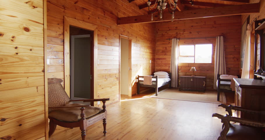 General view of bedroom with beds and armchairs in log cabin, slow motion. Interior, design and countryside concept.